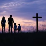 silhouettes-family-standing-before-large-cross-field-sunset (1)